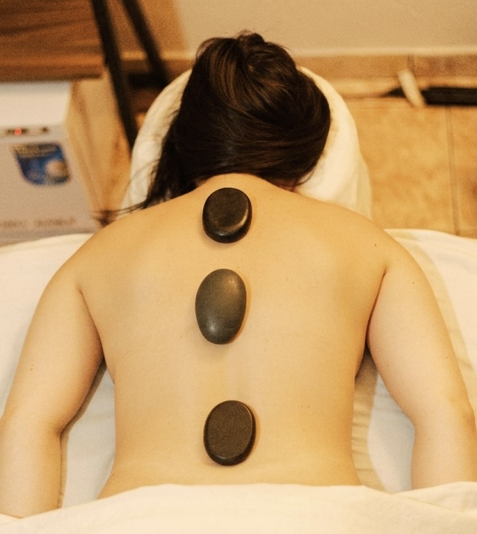 Hot volcanic stones aligned along the spine during a massage