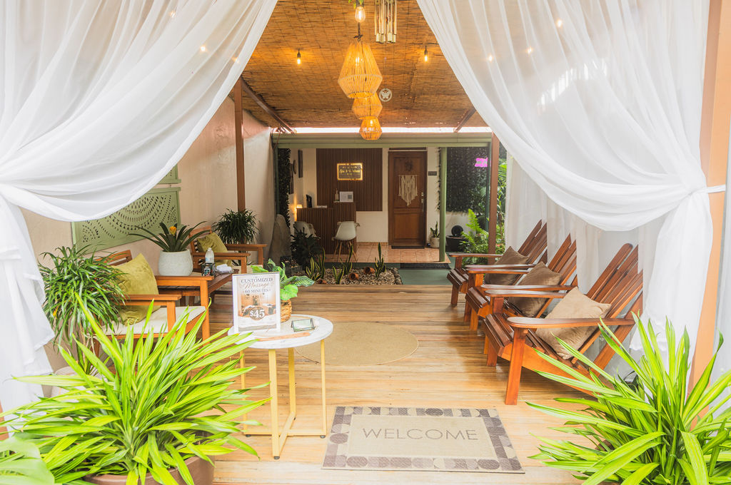 Spa entrance with white drapes and a tropical garden